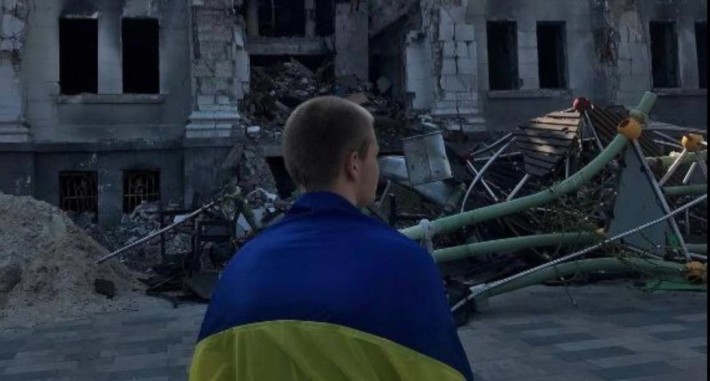 У Маріуполі хлопець вийшов на площу біля розбомбленого Драмтеатру з прапором України (фото)